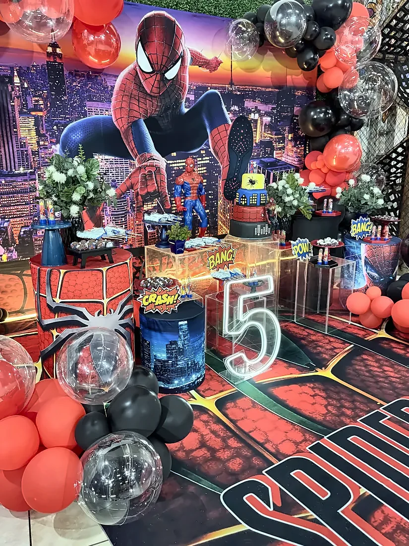 Decoração temática de festa com balões, painel e mesa do bolo