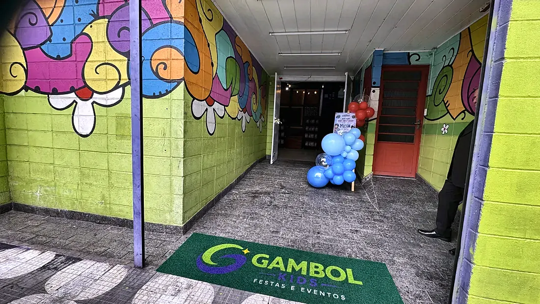 Corredor de entrada da Gambol Kids com painel colorido e tapete da marca