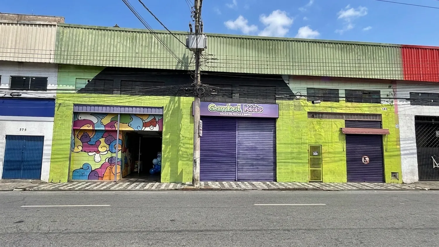 Fachada da Gambol Kids: prédio verde e roxo com o letreiro Gambol Kids Salão de Festas e Buffet