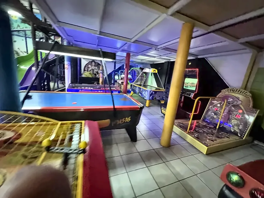 Sala de fliperamas com mesa de air hockey e máquinas de jogos