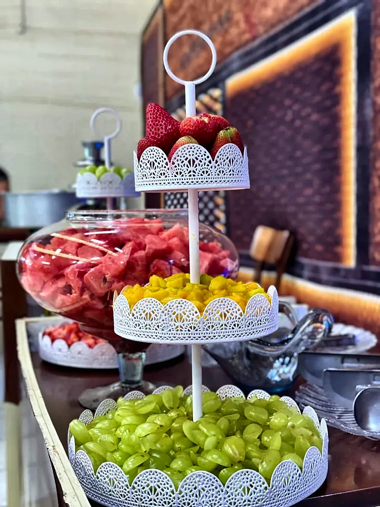 Baleiro com morangos, uvas e abacaxi na mesa de doces