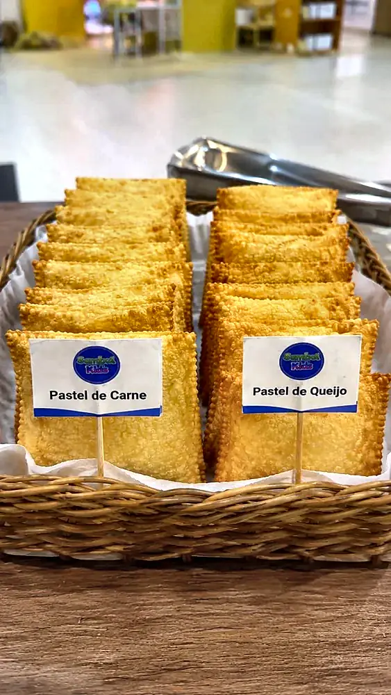 Cesta com pastéis de carne e de queijo identificados por plaquinhas
